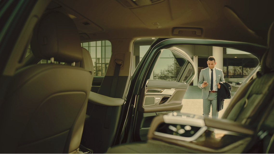 Business traveller arriving at a chauffeured vehicle.